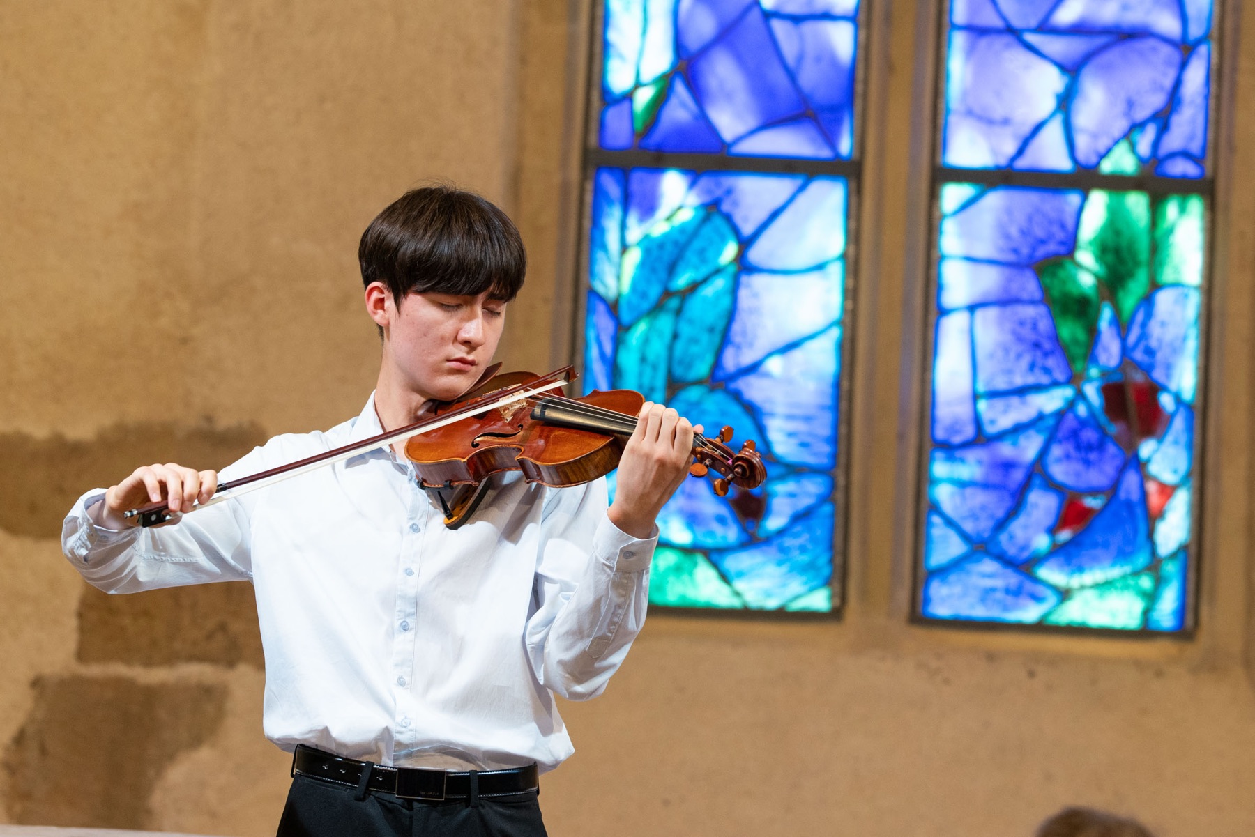 Jeune violoniste devant les vitraux de Chagall dans la chapelle du Saillant